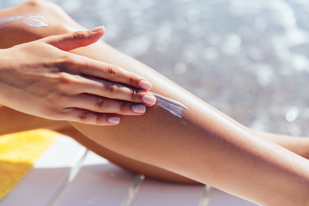 close-up-view-female-hand-applying-sunscreen-her-leg-near-sea