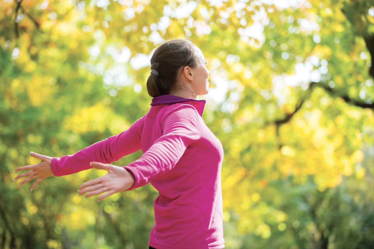 portrait-woman-outdoors-sportswear-hands-outstreched