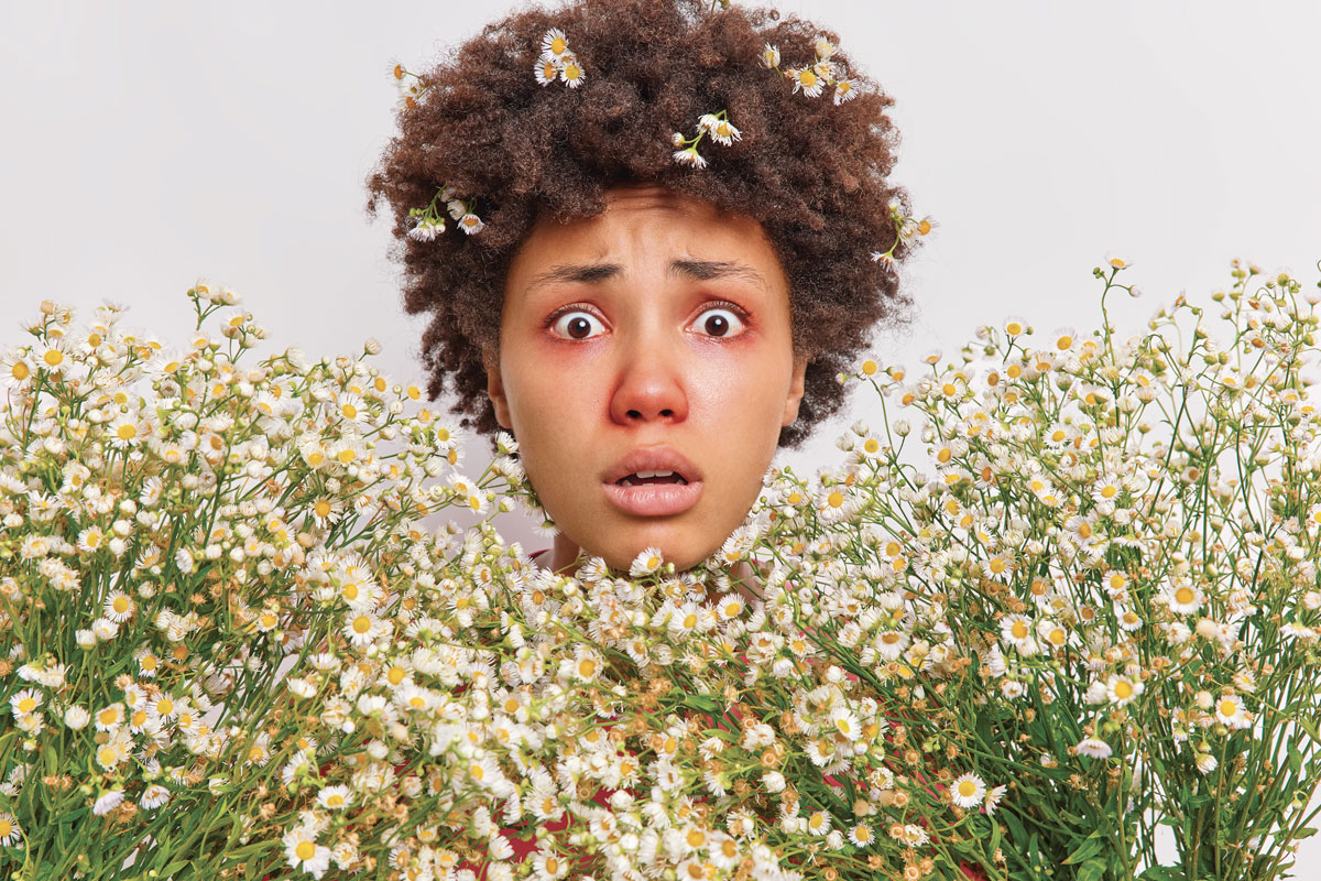 woman-surrounded-by-camomile-has-allergic-reaction-wildflowers-stares-has-red-swollen-eyes-poses-white