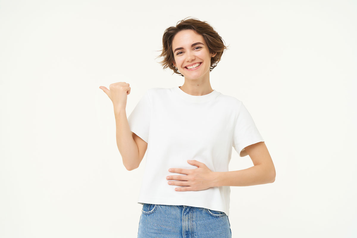 happy-healthy-young-woman-pointing-left-showing-advertisement-touching-her-belly-feeling-better