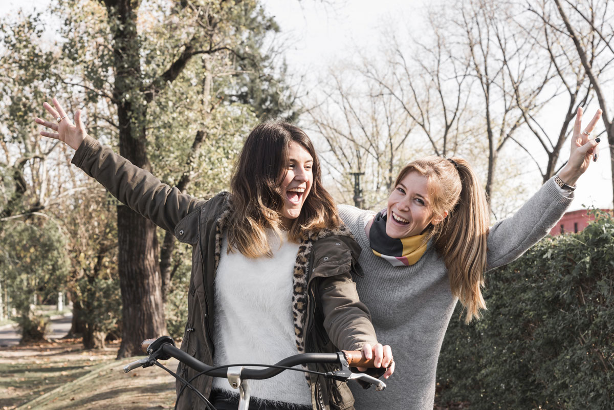 happy-women-riding-bike-park
